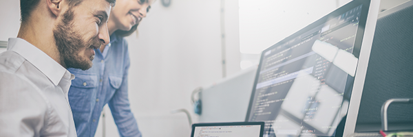 Personen, die auf zwei Computerbildschirme schauen, auf denen ein datenbasierte Architektur angezeigt wird.
