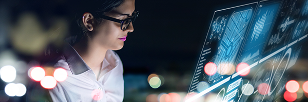IT woman sitting an an IT office and looking at a virtual display of out-of-the-box dashboards of device analytics.